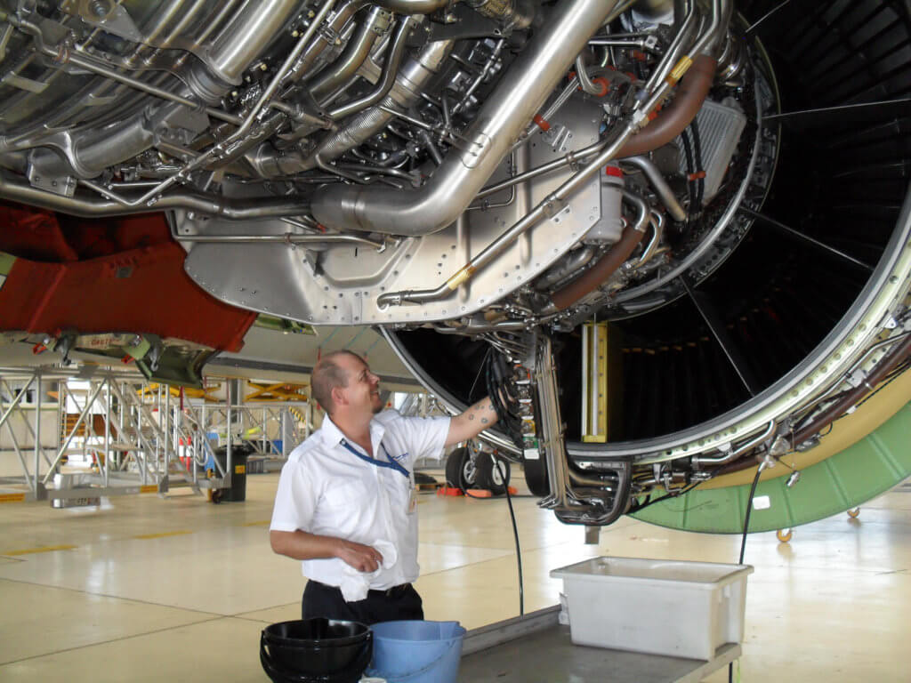 A defense contractor working on gas turbine engine maintenance